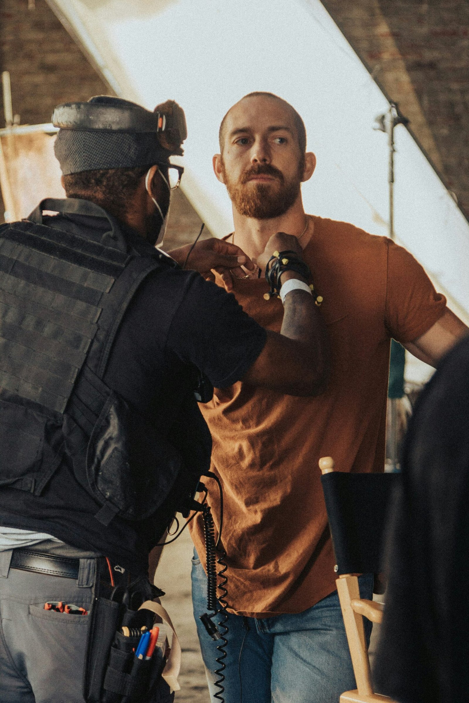 a man in a brown shirt is talking to a man in a brown shirt